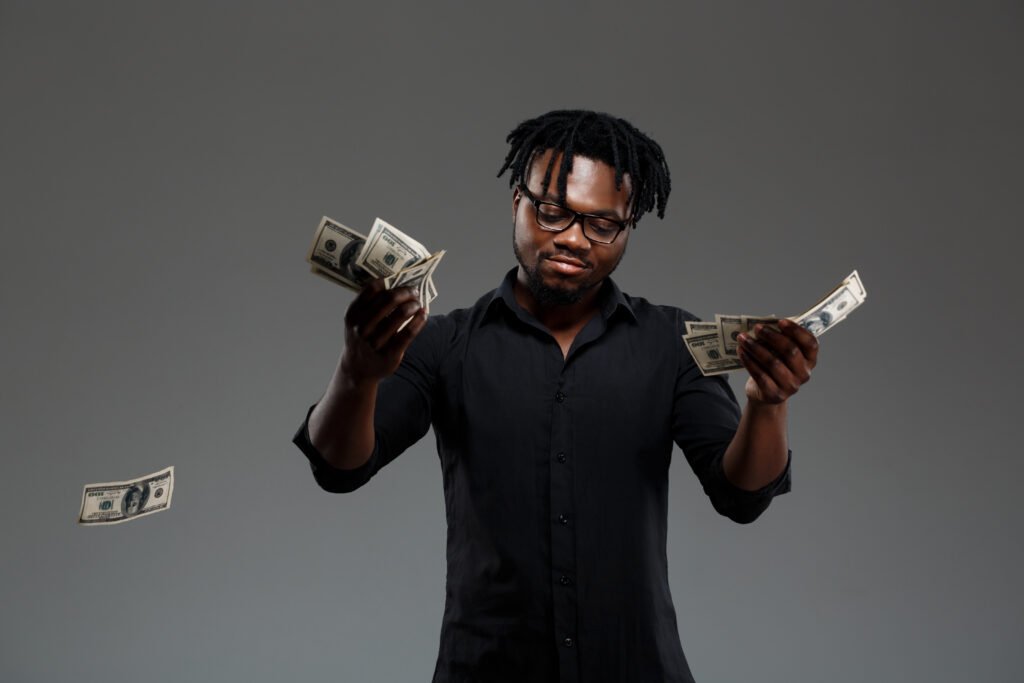 Jeune homme d'affaires africain à succès lançant de l'argent